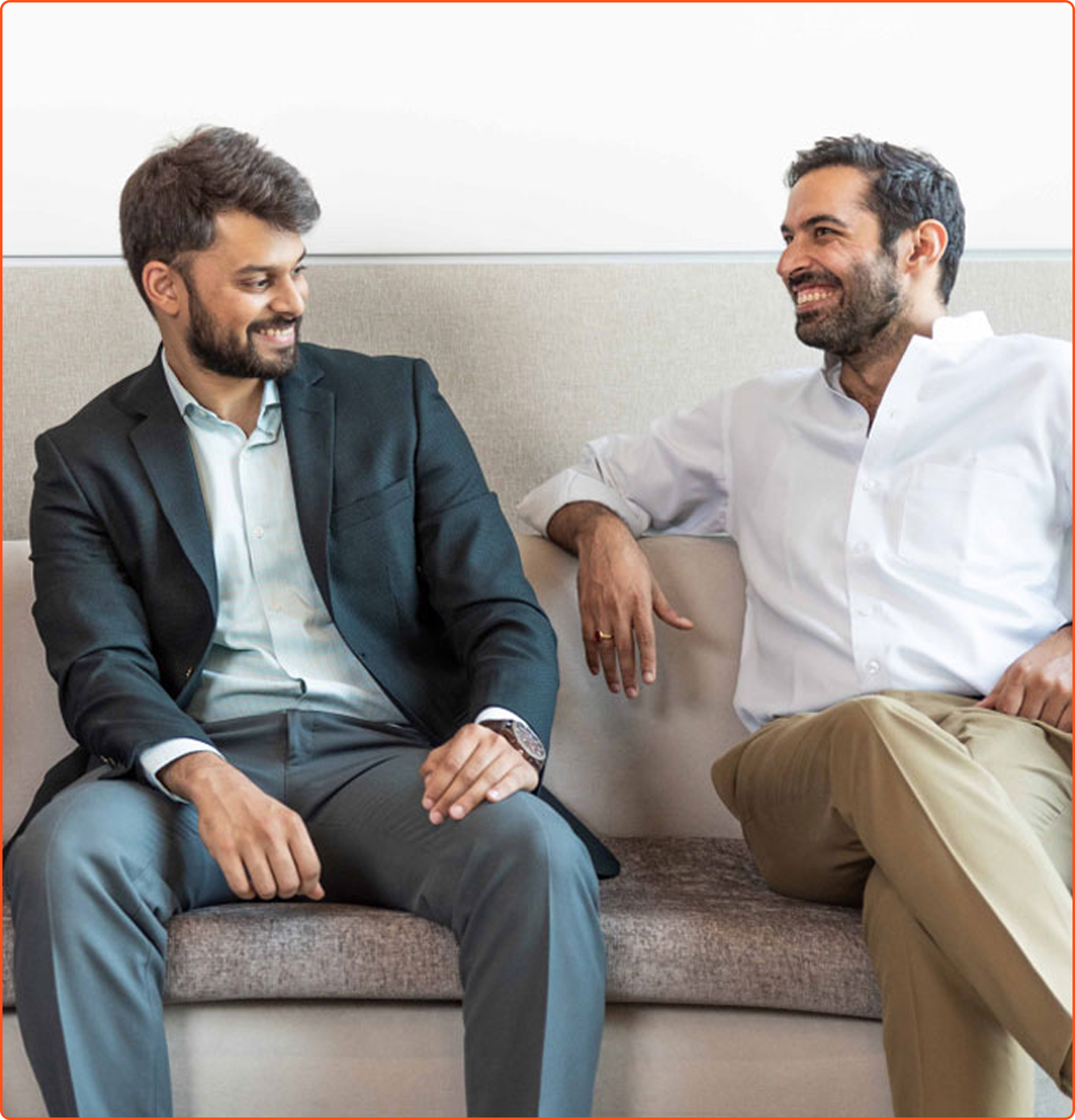 Two smiling colleagues discussing work